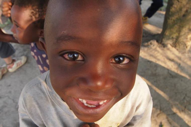 A young boy smiling up at the camera