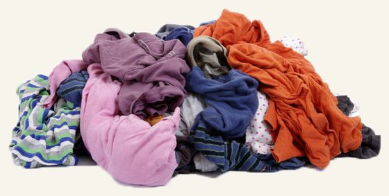 A heap of folded and tumbled clothing in many colours.